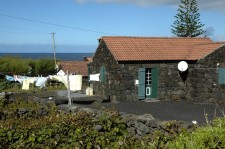 An unpainted house of black volcanic rock, on the North coast